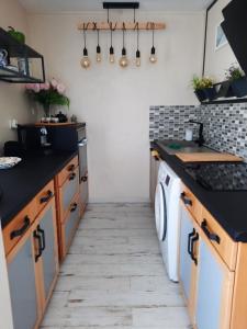 拉特斯特德布赫Dune的厨房配有黑色台面、洗衣机和烘干机