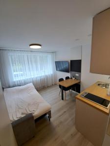 克莱佩达New cosy Karklu Apartment in Klaipeda的客厅配有床和桌子