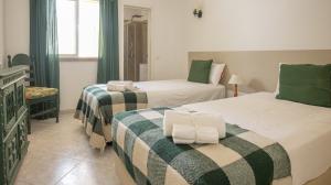 维拉摩拉Villa Aldeia do Golf - BY BEDZY的一间卧室配有两张带绿色和白色毯子的床