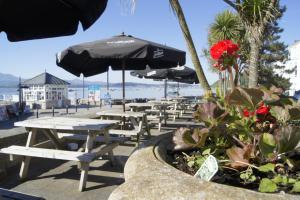 波马利斯宝其利酒店的海滩上的一排野餐桌和遮阳伞