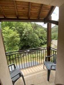 梅吕埃江特德拉酒店的阳台配有两把椅子,享有树林美景