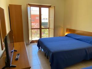 Castelluccio InferioreHotel Mercure的一间卧室设有两张床、一台电视和一扇窗户。