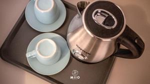 圣温琴佐MIIO HOTEL的茶壶和盘上的杯子