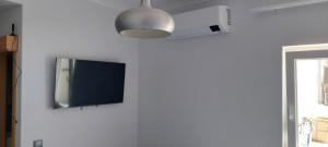 圣地亚哥-杜卡森Alojamento Local - Covas的挂在白色墙壁上的平面电视