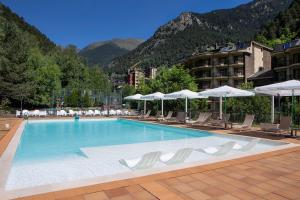 阿林萨尔Hotel Sant Gothard的一个带椅子和遮阳伞的大型游泳池