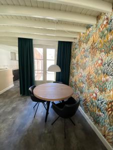 戈伊斯Slot Oostende的用餐室配有桌椅和壁画