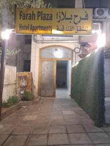 亚喀巴Farah Plaza Hostel &Hotel Apartments的带有门和标志的酒店入口