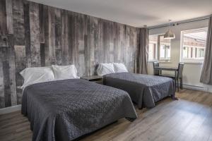 拉马巴耶Le 2020 Charlevoix的一间卧室设有两张床和木墙