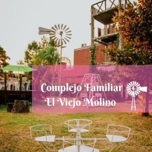 帕特拉德拉帕特拉Complejo Familiar EL VIEJO MOLINO的餐厅的标志,带椅子和风车