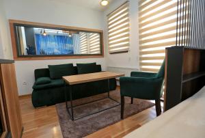 亚霍里纳Apartman KUTAK Jahorina的客厅配有绿色沙发和桌子