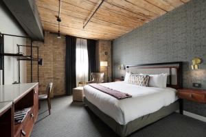 明尼阿波利斯Hewing Hotel的酒店客房设有一张大床和一张书桌。