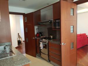 基多蓝色地带公寓酒店的厨房配有棕色橱柜和炉灶烤箱