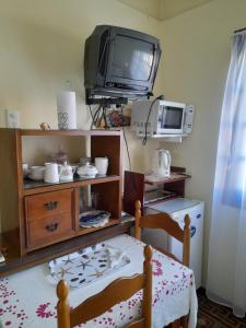科洛尼亚-德尔萨克拉门托Casa una habitación的客厅配有电视、桌子和电视机