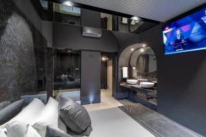卡塔尼亚4 Suites " unconventional living rooms "的一间配有沙发的浴室和一台电视机。
