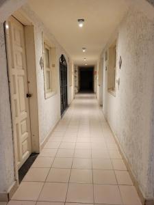 圣克里斯托瓦尔-德拉斯卡萨斯Hotel Dulce Luna的空的走廊,有白色的墙壁和瓷砖地板