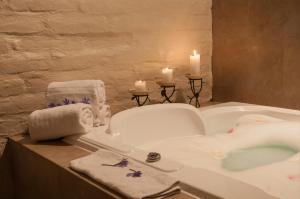 里奥班巴阿布拉普格庄园酒店的浴室配有带蜡烛和毛巾的浴缸。