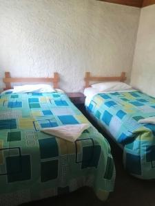 科万Posada Montaña del Quetzal的两张睡床彼此相邻,位于一个房间里