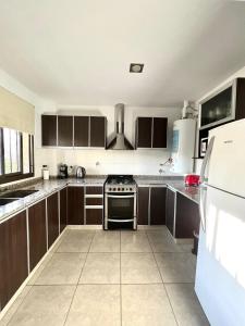 门多萨Luminoso departamento en zona residencial的厨房配有棕色橱柜和炉灶烤箱