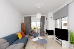 依克希亚Naya Ixia Rhodes Apartment的客厅配有蓝色的沙发和电视