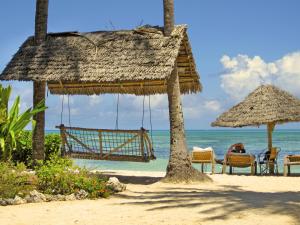 江比阿蓝牡蛎酒店的海滩上设有椅子和遮阳伞,大海