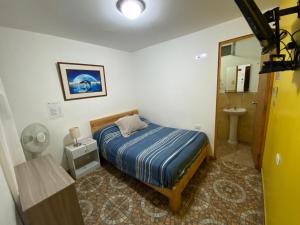 帕拉卡斯阿特纳斯背包客旅舍的一间带床的小卧室和一间浴室