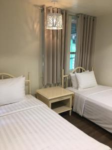 Santa RitaMySpace @Subic的一间卧室配有两张床和吊灯。