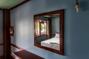 Ban KhonNongsak Riverside Guesthouse & Nongsak Guesthouse的墙上的镜子,房间里的床