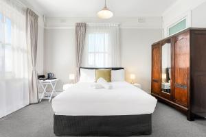 温特沃斯瀑布君怡酒店的卧室设有一张白色大床和一扇窗户。