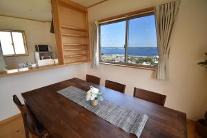 KamegawaBep one the house with ocean view的一间带桌子和大窗户的用餐室