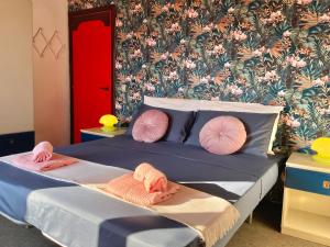 滨海弗兰卡维拉Villetta sul mare的一间卧室配有带粉红色枕头和壁纸的床