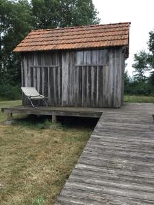 ThaimsCabane au fond du jardin的木制小屋,在木甲板上设有长凳