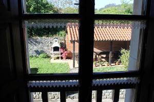 SelorioRodiles Rural Apartamentos的从房子的窗户可欣赏到花园景色