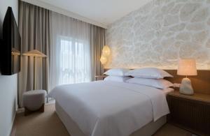 图彻皮Heritage Hotel Kaštelet的卧室设有一张白色大床和一扇窗户。