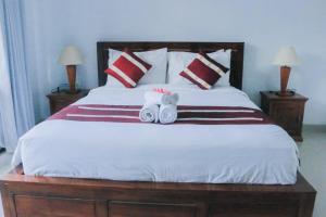 珀尼达岛Sambu Bungalow的一间卧室配有一张床,上面有两条毛巾
