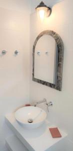 普拉提伊亚洛斯西弗诺斯奥斯提亚公寓的浴室设有白色水槽和镜子