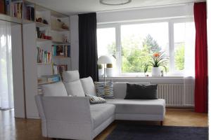 卡塞尔Das Blaue Haus - Ferienwohnung Schönherr的客厅配有白色沙发和窗户