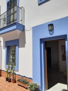 圣玛丽亚港Villa Puerto Santa María的一座蓝白色的建筑,有门和植物