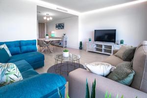 圣罗克Emerald Green 2380 Golf & beach的客厅配有蓝色的沙发和平面电视。