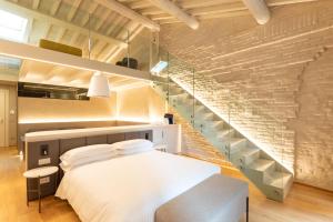 曼托瓦Scaravelli Residenza的一间卧室设有一张床和一个楼梯