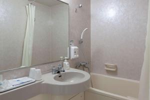 天童市天童康福特茵酒店的浴室配有盥洗盆、镜子和浴缸