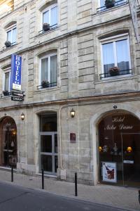 波尔多巴黎圣母院酒店的一座带窗户和商店的大型石头建筑