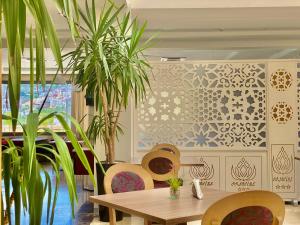 得土安Prestige Hotel & Spa的一间设有桌子和一些植物的用餐室