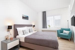 奥拉迪亚Charlotte Piata Unirii - Free Parking 2bedrooms Apartment的一间卧室配有一张床和一张蓝色椅子