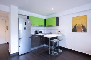 戛纳Agréable studio en centre-ville的厨房配有绿色橱柜和白色冰箱