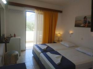 阿彻奇洛斯纳基索斯酒店的酒店客房设有两张床和大窗户。
