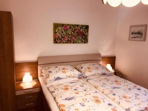 BrauneggBraunegger-Hof Waldviertel的卧室配有一张床,墙上挂有绘画作品