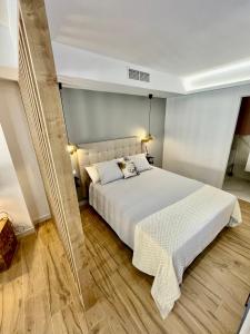 阿利坎特Ágata 10-4E的卧室配有一张白色的大床,铺有木地板