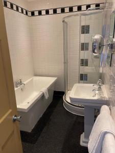 约维尔Manor Hotel by Greene King Inns的白色的浴室设有浴缸和水槽。