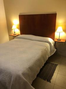 卡塔马卡Departamento Ensueño的一间卧室配有一张带两盏灯的大型白色床。