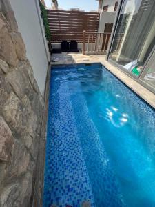 赫尔格达Lovely 1BR with Private Heated pool at El-Gouna的一座位于房子一侧的蓝色瓷砖游泳池